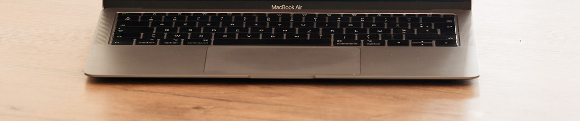 Open MacBook Air on a wooden desk.