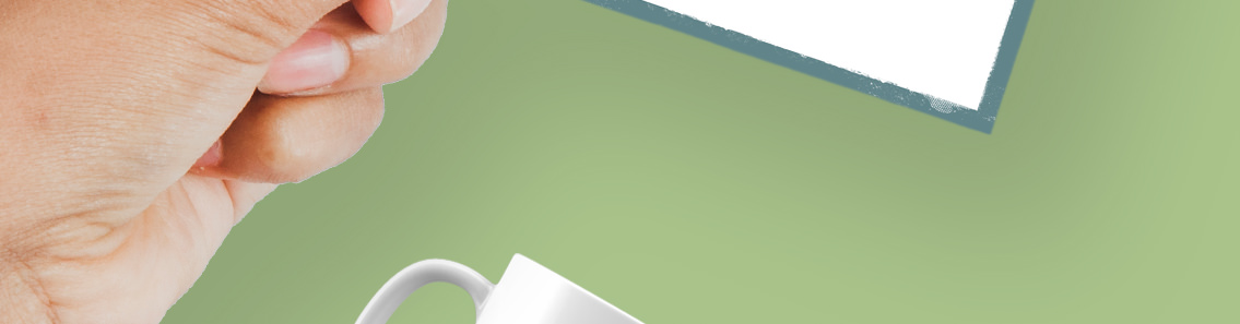 Part of a hand, part of a mug, part of a business card, all on a green background.