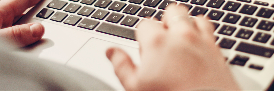 Man’s hands typing on a MacBook’s keyboard.
