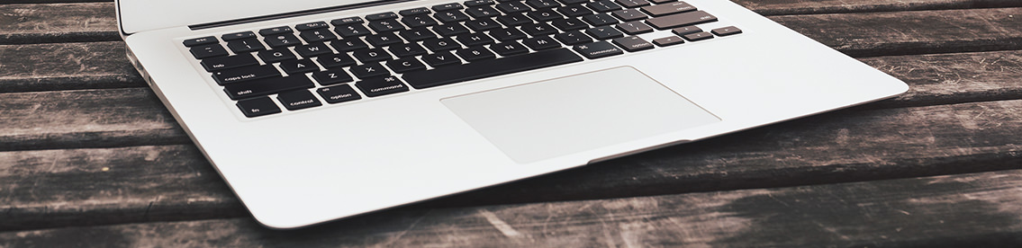 Detail of Mac keyboard on rustic wood table.